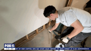 After flood cutting the soaked basement dry wall, Paul Davis sprays antimicrobial to disinfect and deter mold damage